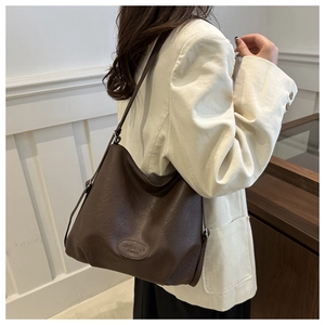 Detail of lychee pattern leather tote bag with embossed logo and brown strap