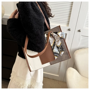 Detail of color-block tote bag with a decorative geometric silk scarf on the handle
