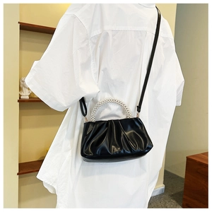 Detail of black cloud bag featuring pleated texture and elegant pearl bead handle