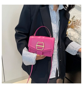 Détail du sac à bandoulière rose rouge avec une boucle métallique carrée dorée