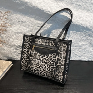 Leopard print tote bag with black leather front pocket and sturdy top handles for women