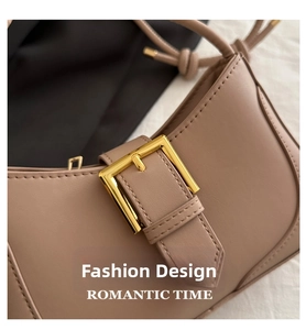 Gros plan du sac croissant kaki clair avec boucle dorée carrée et surpiqûres précises