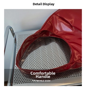 Detail of red glossy leather tote bag with comfortable handle on industrial background
