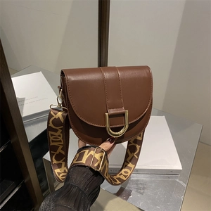 Brown leather saddle bag with gold horseshoe buckle and wide patterned strap