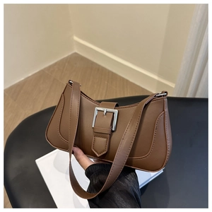 Detailed close-up of the vintage brown crescent bag with a bold silver metal buckle