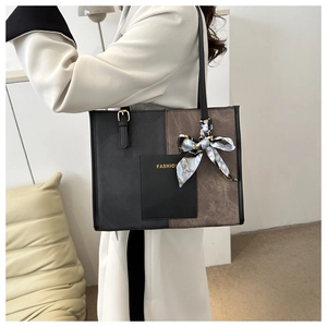Detail of two-tone tote bag with a fashion logo pocket and elegant printed silk scarf