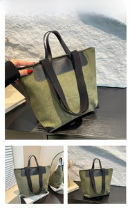 Detail view of green corduroy tote bag with black leather handle and reinforced base