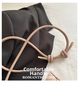 Détail de la poignée en cuir beige avec coutures fines et finitions en métal doré