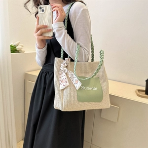 Sac fourre-tout en paille avec anses vertes et détail de foulard en soie d'été