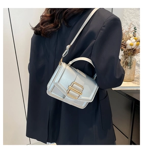 Détail du sac bandoulière argenté métallisé avec grande boucle dorée et lanière
