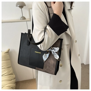 Detail of a contrast tote bag with FASHION patch and polka dot scarf accessory