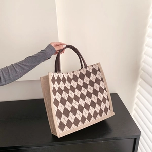 Detailed view of the brown argyle canvas tote bag with woven trim and round handles