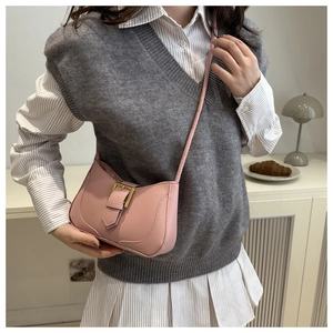 Détail d'un sac porté épaule rose vintage avec boucle dorée sur cuir texturé fin