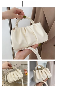 Close-up of elegant cream white dumpling bag featuring multilayered pearl beaded handle