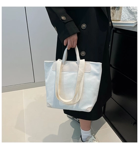 Detailed shot of beige corduroy tote bag showing striped fabric and leather corners