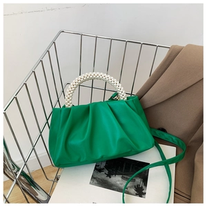 Detail of emerald green cloud bag with pearl handle and soft pleated faux leather texture