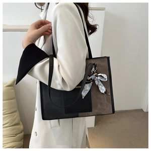 Detail of contrast tote bag with black leather and brown suede featuring a polka dot scarf