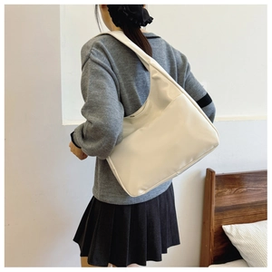 Detail view of large cream tote bag with textured faux leather and wide shoulder strap