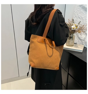 Detail of caramel corduroy tote bag with leather patchwork texture on a female model