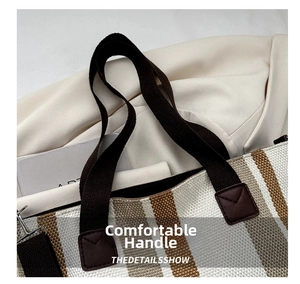 Detail of striped canvas tote bag showing reinforced leather patches and woven handles