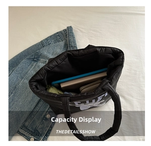 Detailed interior view of a black quilted puffer bag showing its large storage capacity