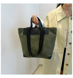 Detailed view of olive green corduroy tote bag with black leather trim and handles