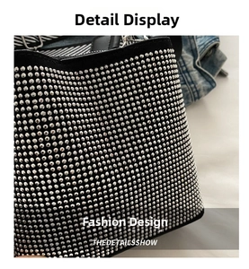 Detailed view of luxury bucket bag with shimmering silver rhinestones and striped strap