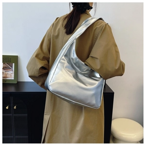 Rear view of a model wearing the silver leather hobo bag with a wide shoulder strap