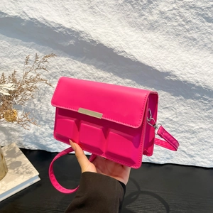 Hot pink shoulder bag with unique chocolate pattern embossing and sleek metal buckle