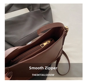 Detailed macro view of gold metal zipper and premium brown leather texture on handbag