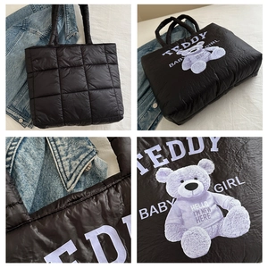 Detail of black quilted tote bag featuring a teddy bear print and soft padded texture