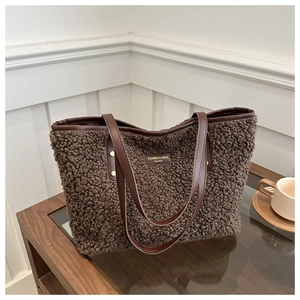 Detail of plush faux fur tote bag in deep brown with smooth leather straps and rivets