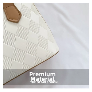 Detail of cream shell bag featuring embossed lattice texture and brown leather stitching