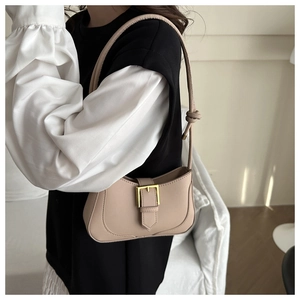 Détail de la texture PU et boucle dorée d'un sac sous les bras beige en forme de croissant
