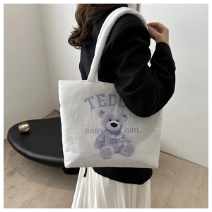 Detail of white puffer tote bag with purple teddy bear print and soft padded handle