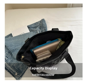 Top view of black quilted tote bag interior showing capacity for umbrella and phone