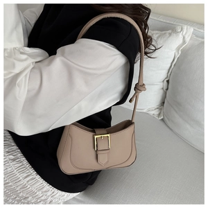Détail de la bandoulière nouée chic et de la boucle dorée de ce sac porté épaule kaki
