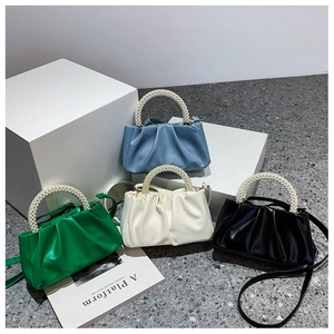 Detail of trendy cloud bags with pearl handles in blue, green, white and black colors