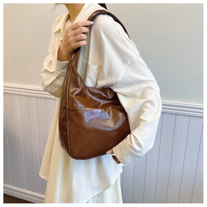 Detail of a large dark brown vintage tote bag in glossy oil wax leather for women