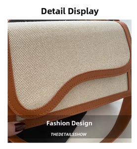 Detail shot of beige canvas crossbody bag with brown leather wavy trim and fine stitching