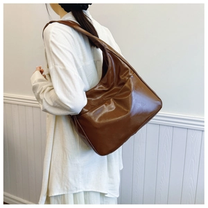 Side view of large brown soft leather hobo bag worn by model for daily commute style