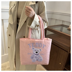 Detail of pink quilted tote bag with purple teddy bear print and soft textile texture