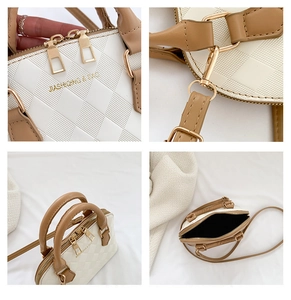 Close-up detail of dual gold zippers, metal hooks, and interior of the beige shell bag