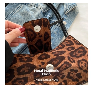 Detailed view of the magnetic closure on a stylish leopard print shoulder bag