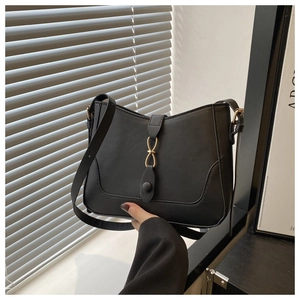 Dettaglio della borsa tote in pelle nera opaca con fibbia circolare in metallo dorato