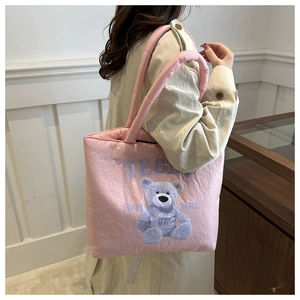 Detailed side view of pink quilted puffer tote with Teddy Baby Girl print and padded handle