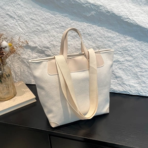 Minimalist beige corduroy tote bag with dual straps and leather trim in home setting