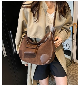 Close-up of vintage brown suede hobo bag with adjustable strap and small square pouch