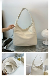 Detail view of large capacity cream tote bag showing interior space and glossy texture