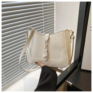 Dettaglio della borsa tote bianca in pelle PU con fibbia dorata a infinito e cuciture a U
